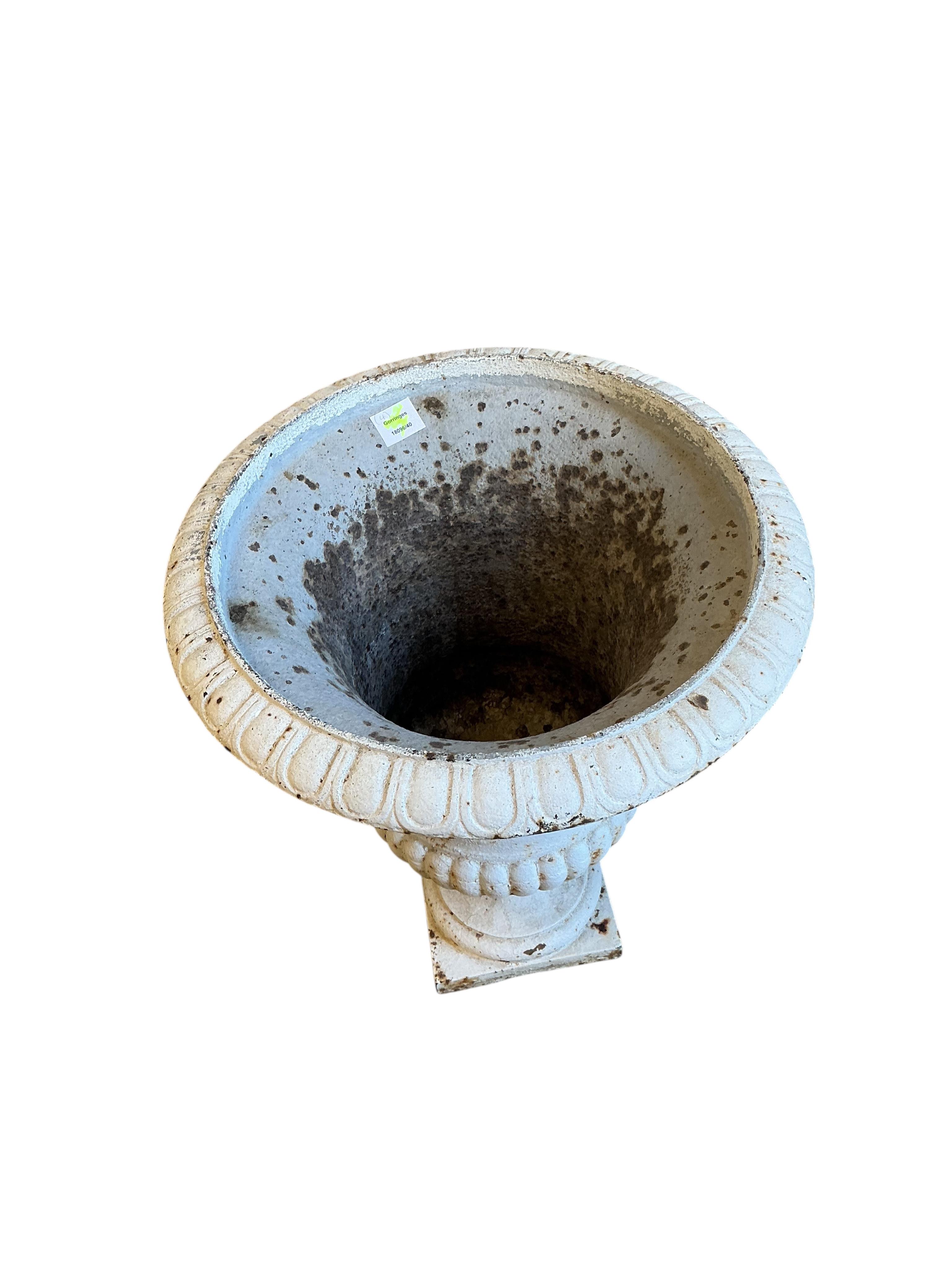 Four Victorian white painted cast iron campana garden urns, diameter 50cm, height 64cm